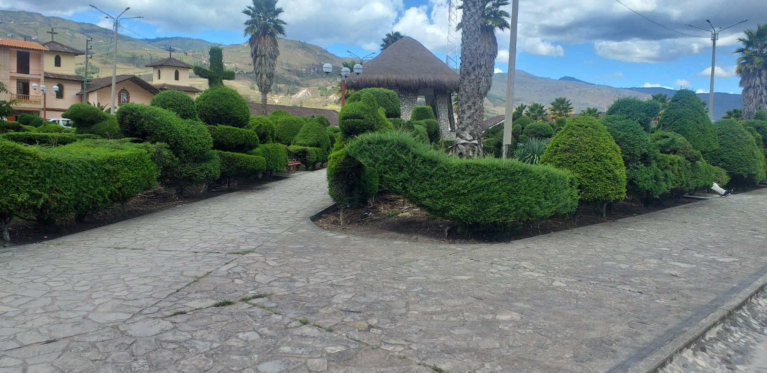 Jardines de la plaza de Nuevo Tingo, con la iglesia y montañas al fondo